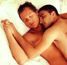 Two men sleeping together in bed